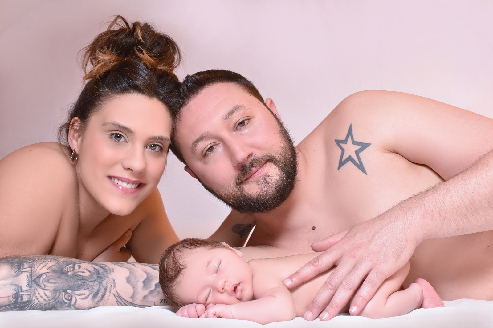 Padres abrazando a su bebé recién nacido al final de su sesión newborn en Fuenlabrada con Hellen Violet