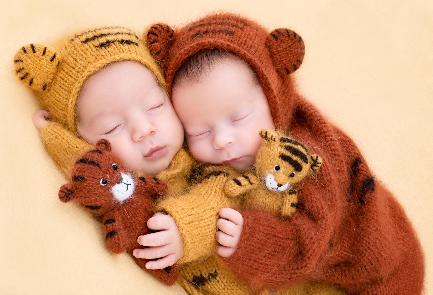 Dos bebés recién nacidos dormidos con gorritos de lana en una sesión newborn en Madrid